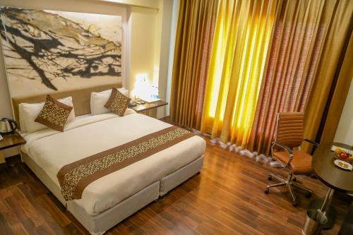 a hotel room with a bed and a window at Four Leaf Hotel,Budaun in Budaun