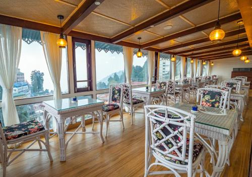 a restaurant with tables and chairs and windows at Yashshree Mall Road Darjeeling in Darjeeling