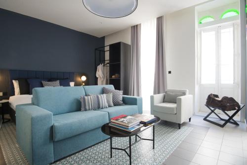 een woonkamer met een blauwe bank en een stoel bij Palazzo Ignazio in Valletta