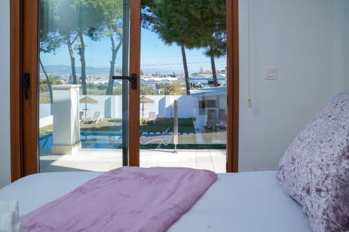 een slaapkamer met een bed en een groot glazen raam bij TESS Villa Maria in Alhaurín de la Torre