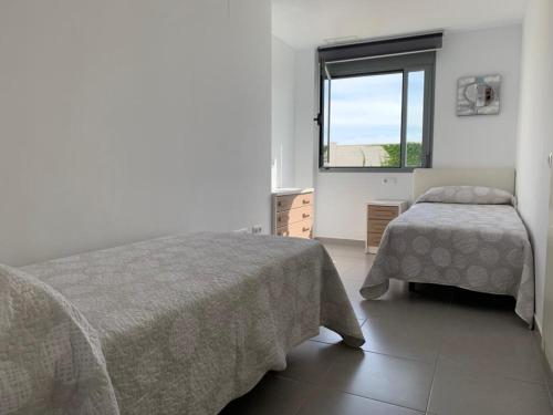 1 Schlafzimmer mit 2 Betten und einem Fenster in der Unterkunft Casa Grullo in Conil de la Frontera