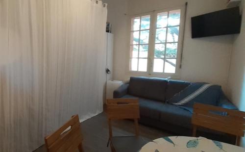 salon z niebieską kanapą i oknem w obiekcie Superbe Studio accès direct à la plage de Renecros Tout à pied linge de lit, serviettes de bain et ménage de fin de séjour inclus w mieście Bandol
