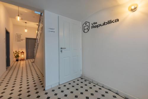 a hallway with a white door and a checkered floor at Wellness Apartmány Vila Republika in Velké Losiny