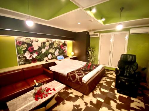 a bedroom with a bed and a couch at ホテル南の風風力3駒ヶ根店 in Komagane