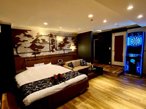 1 dormitorio con cama y videojuego en ホテル南の風風力3駒ヶ根店, en Komagane