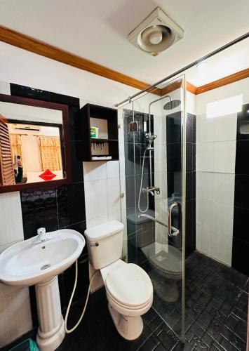 a bathroom with a toilet and a sink and a shower at Singharat Boutique House in Luang Prabang