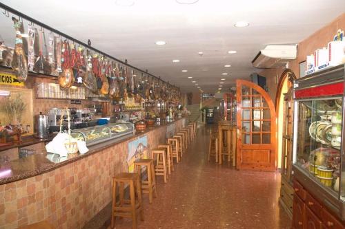 un restaurante con un bar con mesas y sillas en HOSTAL-RESTAURANTE EL PAISANO, en Guadalema de los Quinteros
