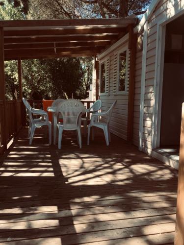 une terrasse avec une table et des chaises dans une maison dans l'établissement parc des 7 fonts, à Agde