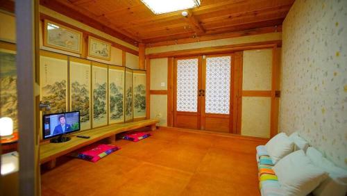 a living room with a tv and a couch in it at Kumwondang Jeonju Hanokstay in Jeonju