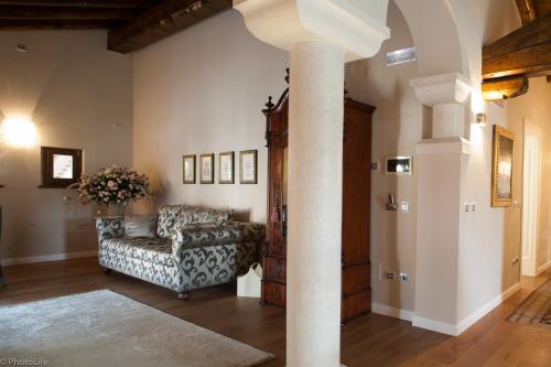 Sala de estar con sofá y columna en Wine Resort Luisa, en Mariano del Friuli