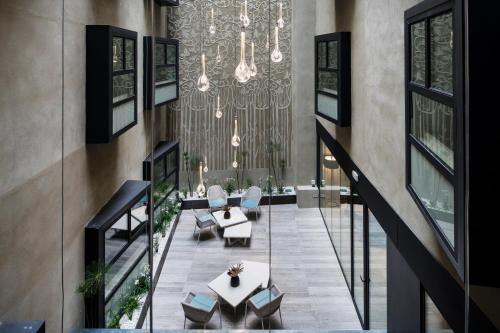 a lobby with a chandelier and a table and chairs at Catalonia Magdalenes in Barcelona