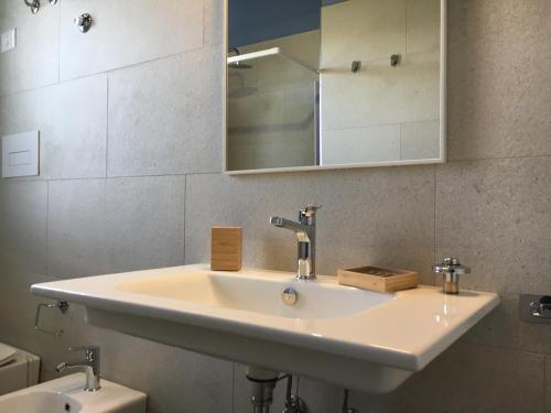 uma casa de banho com um lavatório, um espelho e um WC. em Azienda agricola Crilù em Milazzo