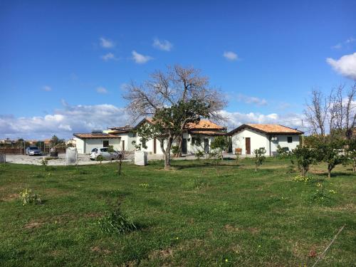 a house in a yard with a grass field at Agriturismo Crilù in Milazzo