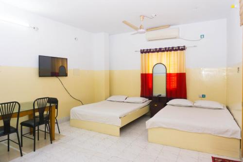 a room with two beds and a table and a tv at Hotel Al-Sarwar (Res.) in RÄjÄrbÄg