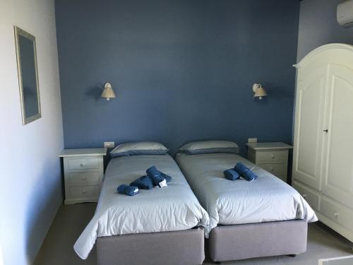 a bedroom with two beds with blue pillows on them at Agriturismo Crilù in Milazzo