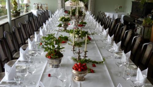 a long table with wine glasses and flowers on it at Restaurant und Hotel Zum Weissen Ross in Mölln