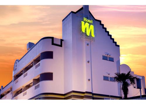 a hotel with a m sign on the side of a building at ホテル南の風風力3駒ヶ根店 in Komagane