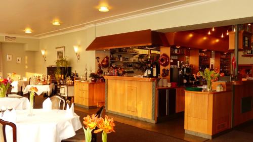 a restaurant with tables and a bar in a room at Restaurant und Hotel Zum Weissen Ross in Mölln