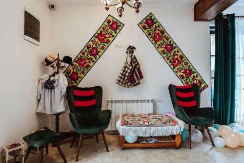 um quarto com duas cadeiras e uma mesa e algumas roupas em Piatra Soimului em Vişeu de Sus