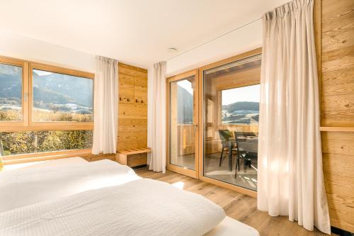 a bedroom with a bed and a large window at Neuhuberhof in Vols am Schlern