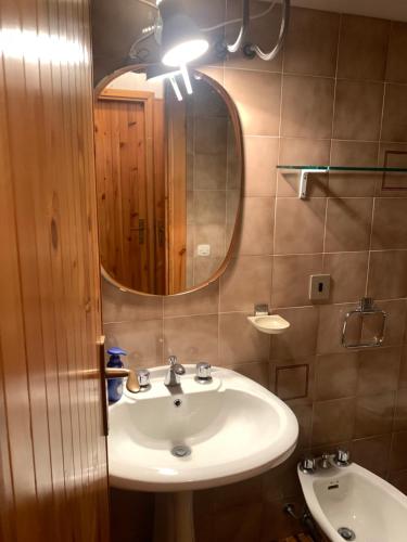 a bathroom with a sink and a mirror at Residence il Cristallo - Appartamento in Ovindoli