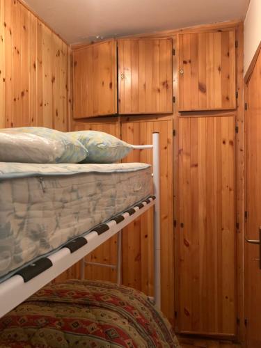 a room with two bunk beds and wooden walls at Residence il Cristallo - Appartamento in Ovindoli