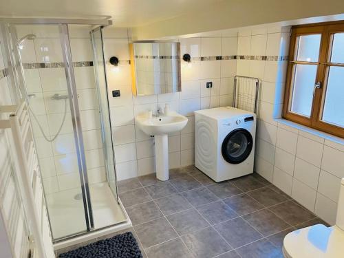 een badkamer met een wasmachine en een wastafel bij Bien dans vos Schlopps in Dambach-la-Ville