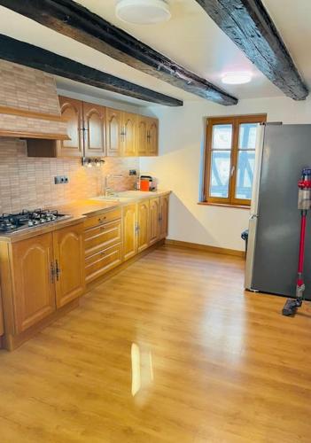 Il comprend une cuisine dotée de parquet et d'un réfrigérateur en acier inoxydable. dans l'établissement Bien dans vos Schlopps, à Dambach-la-Ville