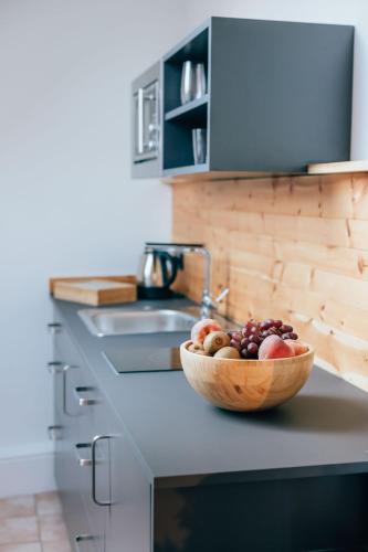 a bowl of fruit on a counter in a kitchen at Hotel Andres in Bamberg