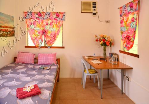 um quarto com uma cama, uma mesa e uma secretária em Guanyin Guesthouse at Rainbow Village em Maricaban