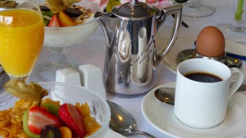 a table with a cup of coffee and a plate of food at Restaurant und Hotel Zum Weissen Ross in Mölln