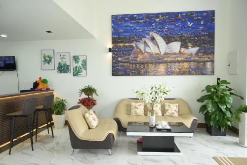 a living room with two couches and a painting on the wall at HAPPY HOTEL Kien Giang in Ấp Rạch Mẹo