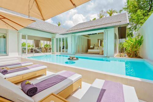 an infinity pool with two beds and a villa at Twin Lotus Resort and Spa - SHA Plus - Adult Only "November - April" in Ko Lanta