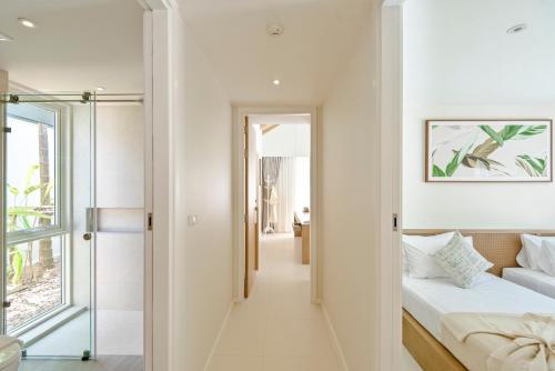 a hallway leading to a bedroom with a bed and a mirror at Twin Lotus Resort and Spa - SHA Plus - Adult Only "November - April" in Ko Lanta