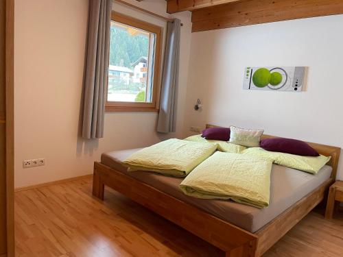 - une chambre avec un lit doté de draps jaunes et une fenêtre dans l'établissement Appartement Carola, à Sankt Gallenkirch