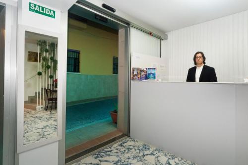 a woman standing behind a counter in a room at Clopy Mirador del Castillo in Benidorm