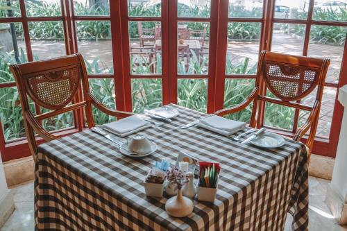a table with a checkered table cloth and two chairs at Settha Palace Hotel in Vientiane