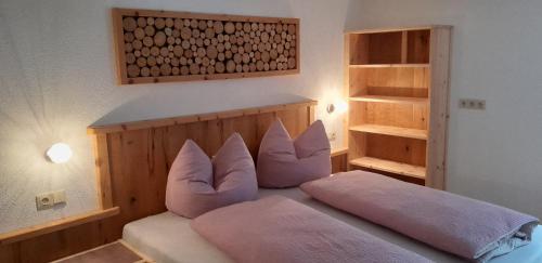 a bedroom with a bed with pink pillows on it at Haus Rottensteiner in Jerzens