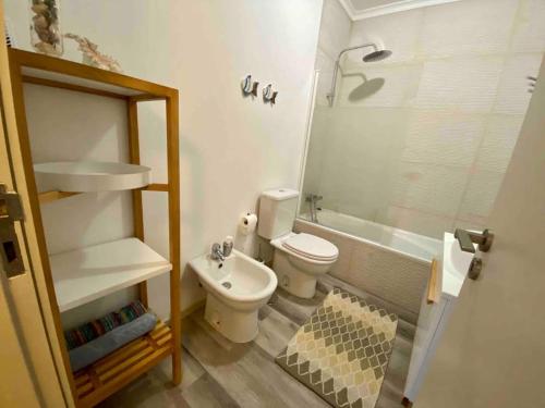 a bathroom with a toilet and a sink and a shower at Rocha’s Apartment REMODELADO! Na praia com terraço in Vila Nova de Gaia