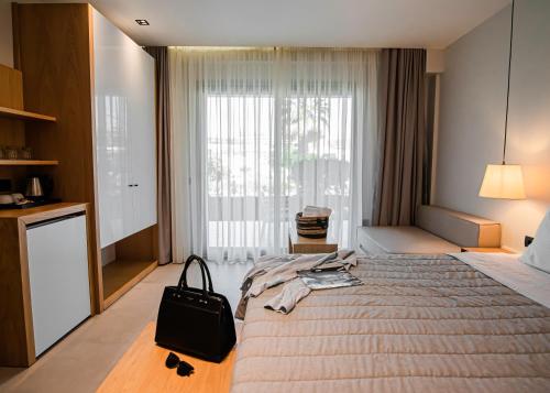 a hotel room with a large bed with a bag on it at Chrousso Village in Paliouri
