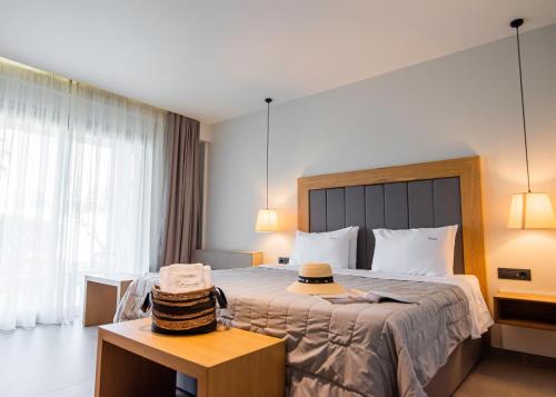 a hotel room with a bed with a hat on a table at Chrousso Village in Paliouri