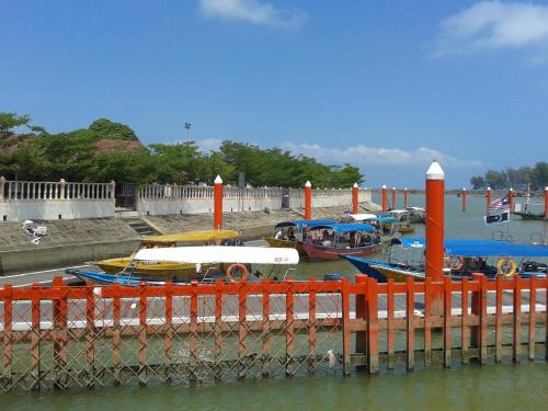 Um monte de barcos estão ancorados numa doca. em IZ Budget em Kampung Kuala Besut