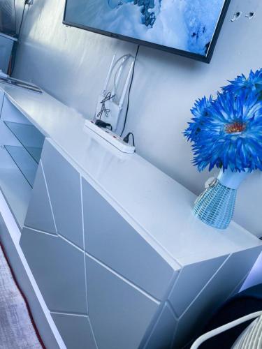 a white shelf with a blue flower in a room at one bedroom airbnb with swimmingpool, kiambu road in Kiambu
