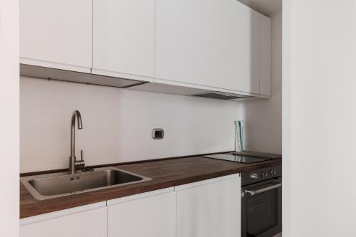 a kitchen with white cabinets and a sink at Torre Capranica in Rome