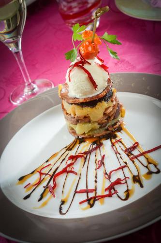 a dessert on a white plate with sauce at Logis Hôtel Restaurant Le Fruitier in Villedieu-les-Poëles
