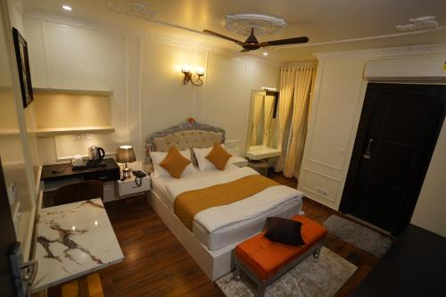 a bedroom with a bed and a desk and a chair at The Royal Hotel in Haldwāni