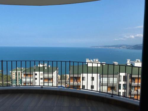 een balkon met uitzicht op de oceaan en gebouwen bij TRABZON YALINCAK TERAS 1 SİTESİ in Trabzon