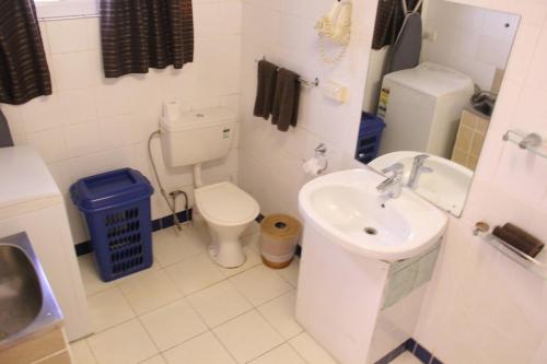 a bathroom with a white toilet and a sink at The Melanesian Port Vila in Port Vila