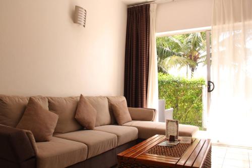 a living room with a couch and a large window at The Melanesian Port Vila in Port Vila