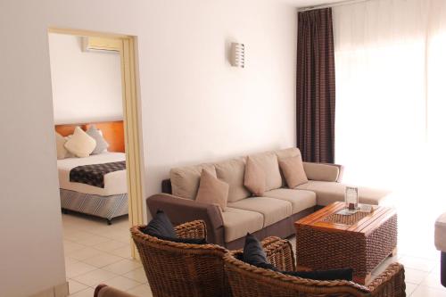 a living room with a couch and a mirror at The Melanesian Port Vila in Port Vila